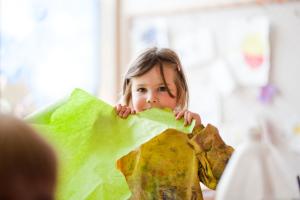 Mädchen mit einem großen Stück Papier beim Basteln